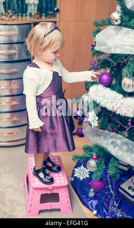 Kleine blonde Mädchen Christmass Baum schmücken Stockfoto