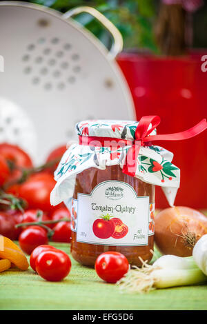 Glas mit Tomaten Chutney und Dekoration im Garten Stockfoto