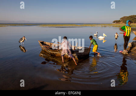Zwei jungen herausschieben ein Fischerboot, See Hawassa, Hawassa, Äthiopien Stockfoto