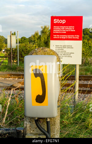 Telefon- und Endzeichen an eine unbemannte und ungeschützten Bahnübergang auf einer Bahnstrecke in der Landschaft, Nottinghamshire, England, Großbritannien Stockfoto