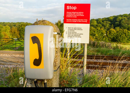 Telefon- und Endzeichen an eine unbemannte und ungeschützten Bahnübergang auf einer Bahnstrecke in der Landschaft, Nottinghamshire, England, Großbritannien Stockfoto