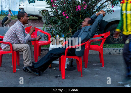 Zwei äthiopische Männer trinken Bier in ein Café im Freien, Hawassa, Äthiopien Stockfoto