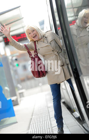 Senior-Frau glücklich Einnahme Straßenbahn Stockfoto