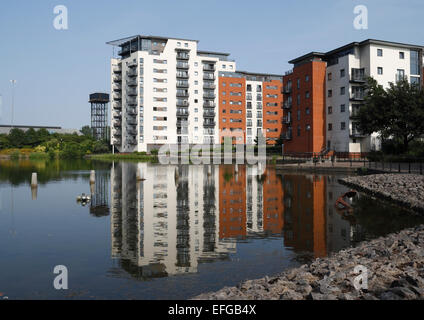 Reflexion eines modernen Appartementblocks im Water Quarter Viertel, Atlantic Wharf Cardiff Bay, Wales, Großbritannien mehrstöckige Wohnhäuser Stockfoto