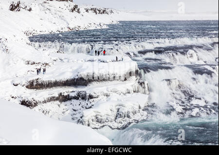 Schroffe Felsen und Wasserfälle in Gullfoss Wasserfall, einer der beliebtesten natürlichen Sehenswürdigkeiten in Island, gefroren mit Eiszapfen im Winter Stockfoto