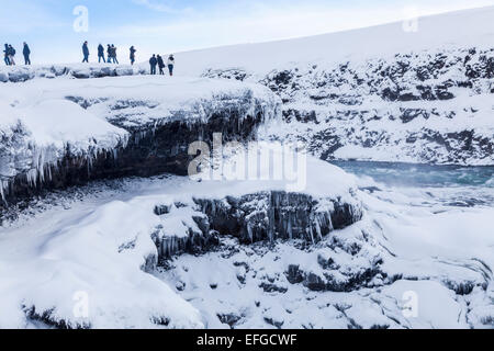 Schroffe Felsen und Schlucht bei Ikonischen Gullfoss Wasserfall, einer der beliebtesten natürlichen Sehenswürdigkeiten in Island, gefroren mit Eiszapfen im Winter Stockfoto