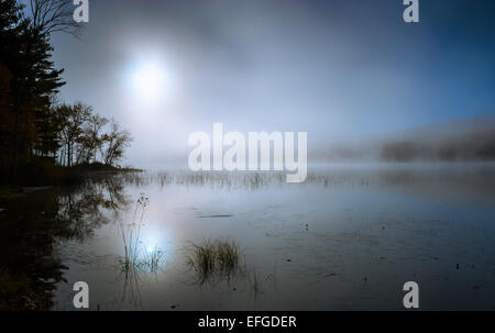 Nebel rollt rund um einen See den ganzen Vormittag. Stockfoto