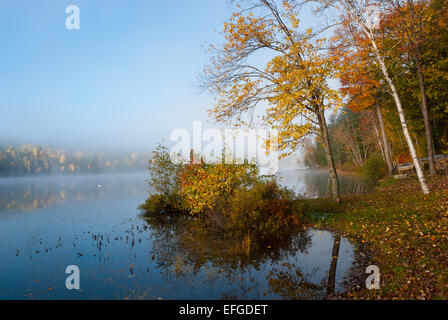 Nebel rollt rund um einen See den ganzen Vormittag. Stockfoto