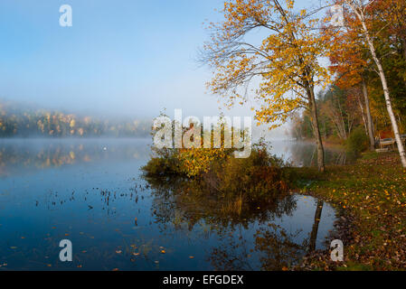 Nebel rollt rund um einen See den ganzen Vormittag. Stockfoto