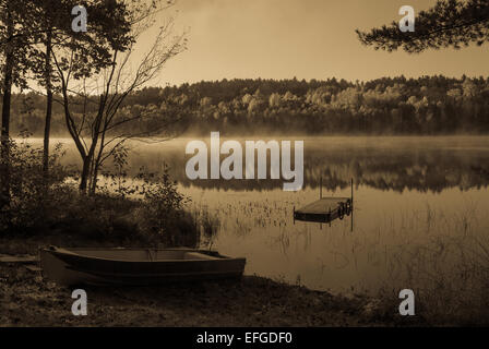 Lakeside Morgen in antiken Licht, die Sonne verbrennt Morgennebel am See. Stockfoto