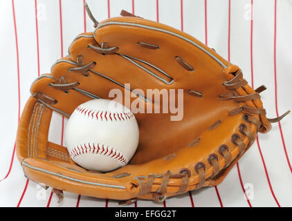 Baseball-Ball in eine Falle auf einem gestreiften Hintergrund. Stockfoto