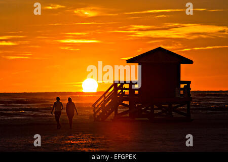 Ein paar ist mit dem Sonnenuntergang über Siesta Key Beach in Sarasota, Florida Silhouette. Stockfoto