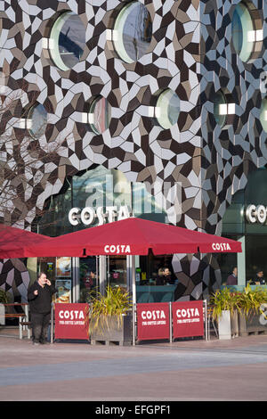 Das Café Costa befindet sich im Februar unter der markanten modernen Architektur des Ravensbourne College am Greenwich Peninsula Square, London, Großbritannien Stockfoto