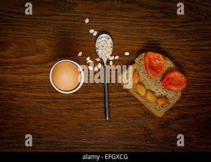 Frühstück: hart gekochtes Ei, Haferflocken Brei oder lustiges Gesicht Toast mit Mandeln und getrockneten Aprikosen für Kinder Stockfoto