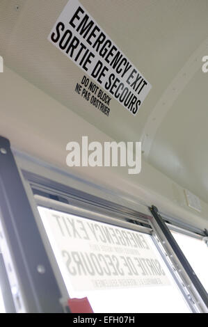 Ein Notausgang Schild in Englisch und Französisch auf dem Dach eines kanadischen Bus. Stockfoto