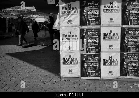 Plakate der neue Premierminister von Griechenland Alexis Tsipras auf Syriza Kampagne Kiosk. Menschen und Straße Musiker schwarz und weiß. Stockfoto