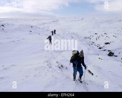 Eine feine Wintertag im Peak District National Park, Derbyshire, UK.  Eine Gruppe von Wanderern Klettern Fairbrook zum Kinder Scout Plateau und wieder nach unten Fairbrook Naze Stockfoto