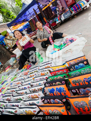 Zwei Lao Frauen verkaufen schöne handgefertigte Handtasche in Luang Prabang Straßenmarkt. Stockfoto