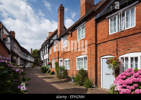 Neben rotem Backstein auf dem Land Häuser mit Blick auf mittelalterliche Periode Fachwerk-, Malt Mill Lane, Alcester, Warwickshire, England Stockfoto