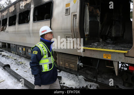 Eine NTSB Unfall-Ermittler Robert Sumwalt sieht den verkohlten Trümmern eine Metro North-Zug-Auto mit einem SUV kollidierte, sechs Menschen getötet und verletzt 12 verletzte 4. Februar 2015 in New York Westchester County. Stockfoto