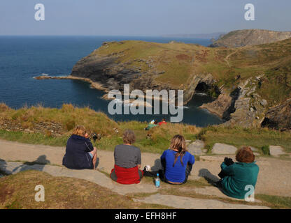 Tintagel Castle Besucher genießen den Blick über den Hafen in Richtung Tintagel Kopf und Merlins Höhle Stockfoto