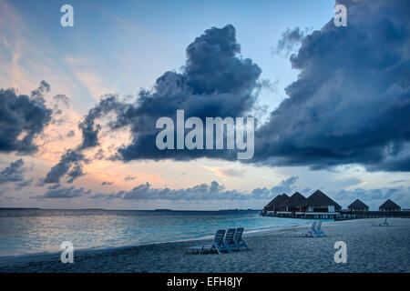 Sonnenuntergang über einem Strand auf einer Insel in den Malediven Stockfoto