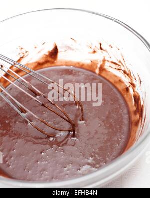 Mischen von Schokolade Teig in eine Glasschüssel für einen Kuchen zu machen. Stockfoto