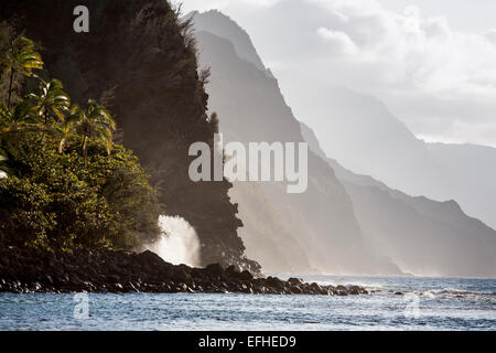 Wellen an der Na Pali Küste. Berge und Täler zurückweichen in Schichten an der berühmten Küste, wie eine riesige Welle stürzt Stockfoto