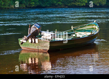 Nahaufnahme von kleinen grünen Holz Ruderboot mit Außenbordmotor für Lachs Angeln am Fluss Tay, Dunkeld, ruhigem Wasser verankert Stockfoto