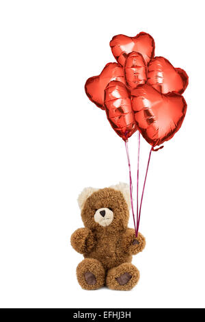Teddybär sitzend mit vielen roten Herzen Luftballons. Stockfoto
