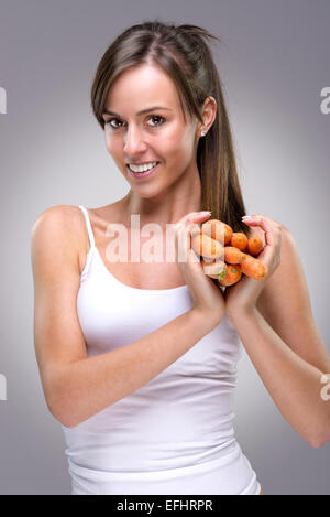 Gesunden Lebensstil! Schöne Frau mit viel Karotten Herzform Stockfoto