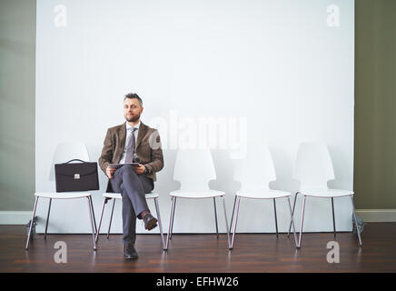 Zuversichtlich Mann in festlich gekleidet wartet auf seine Wendung zum interview Stockfoto