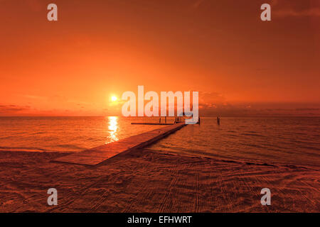 Strand mit Bootssteg im Morgenlicht bei Sonnenaufgang, Moorings Village Resort Islamorada, Florida Keys, Florida, USA Stockfoto