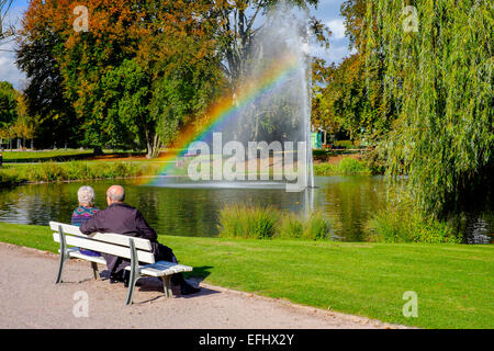 Ältere Paare auf der Werkbank, Wasserstrahl mit Regenbogen, Parc de l'Orangerie Park, Straßburg, Elsass, Frankreich, Europa Stockfoto