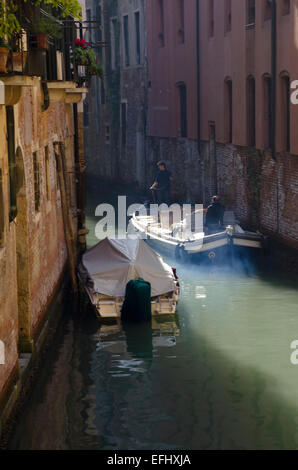 Boot auf einem ruhigen Kanal in Venedig, Italien Stockfoto