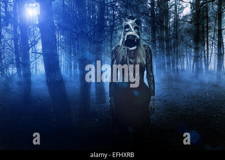 Frau in Gasmaske mit Schlange im Wald Stockfoto