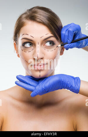 Schöne Frau mit Darstellung, plastische Chirurgie, plastischer Chirurg Hände Stockfoto