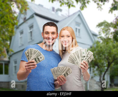 lächelnde paar Anzeigen Geld über Haus Hintergrund Stockfoto