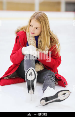 junge Frau fiel auf Eisbahn Stockfoto