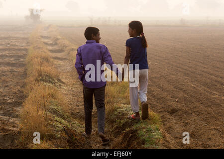 Indien, Uttar Pradesh, Agra, Bruder und Schwester, die Hand in Hand zu Fuß in Feld Stockfoto