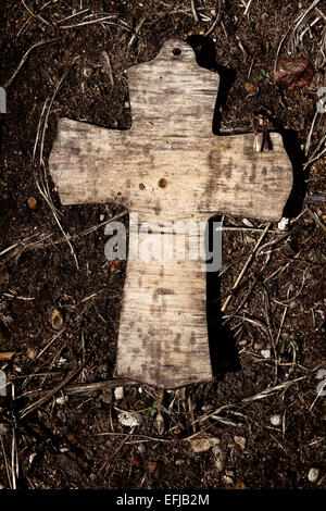 Alte hölzerne Kreuz auf einem Boden liegend Stockfoto