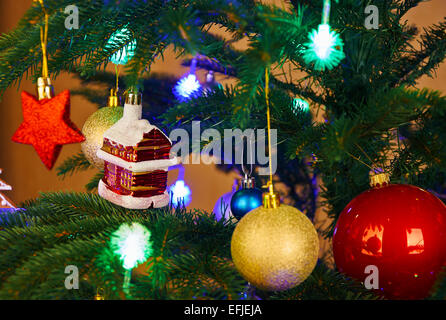 Weihnachtsschmuck und Farbe leuchtet über künstliche Tanne Stockfoto