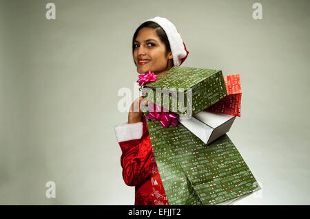 Lächelnde junge Frau mit Weihnachtsgeschenken Stockfoto