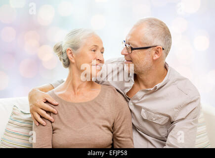 gerne älteres paar umarmt zu Hause auf sofa Stockfoto