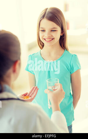 Ärztin, die er Pillen und Wasser für Kind Stockfoto