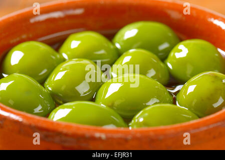 Schüssel mit grünen Oliven in Öl Stockfoto