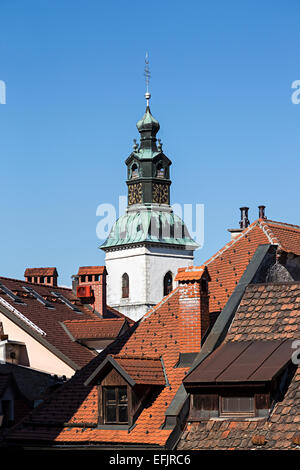 Turm der Kirche erhebt sich über rot gefliest Häuser, Skofja Loka, Slowenien Stockfoto