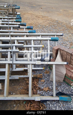 Stapel von Leitern am Boden auf einer Baustelle. Stockfoto