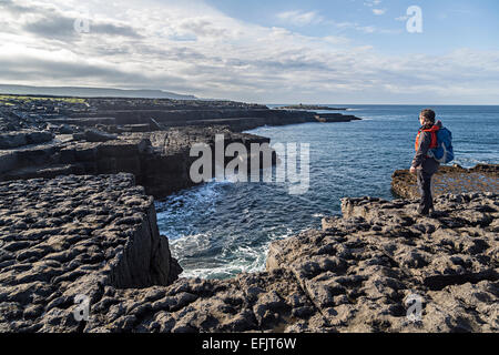 Frau stehend auf Kalkstein felsigen Landzunge in Doolin, Co. Clare, Irland Stockfoto