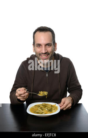 Junger Mann Essen Gemüsesuppe Stockfoto